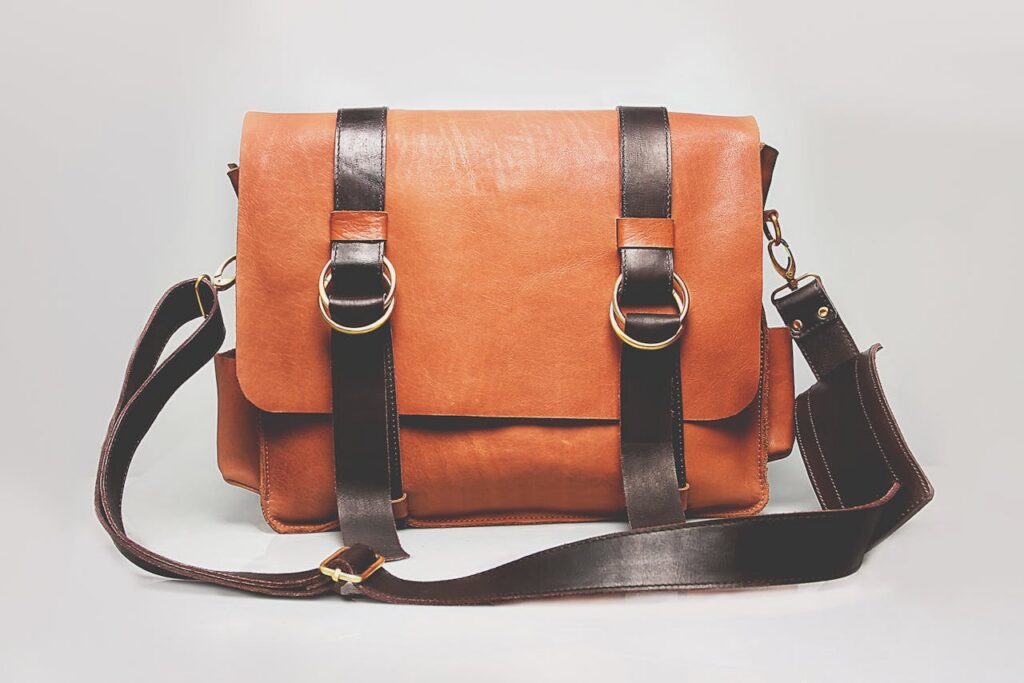 pexels photo 1152077 Elegant brown leather briefcase with dark straps and metal buckles, ideal for fashion and business.